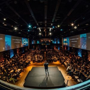 speaker on stage addressing large audience
