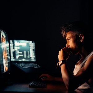woman in black tank top sitting in front of computer