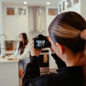a woman taking a picture of herself in a kitchen